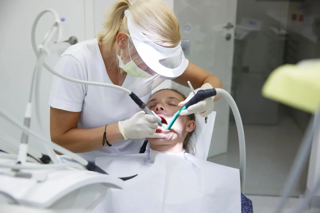 Dental hygienist cleaning patient’s teeth during appointment Murphy Dental
