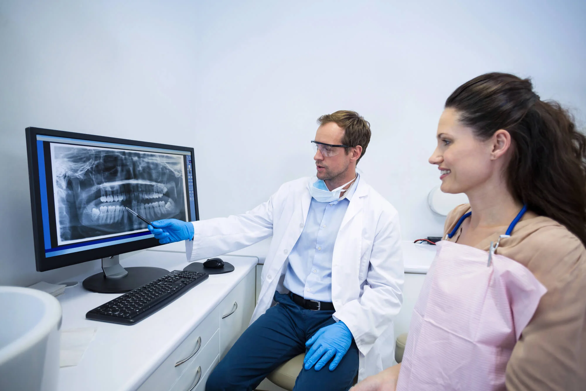 Dentist reviewing dental X-ray with patient dental bonding Mount Holly